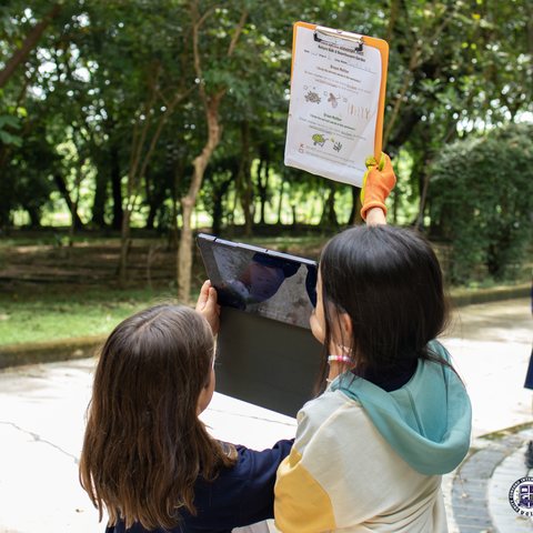 Students gathering photos outdoors for their Google Sites page