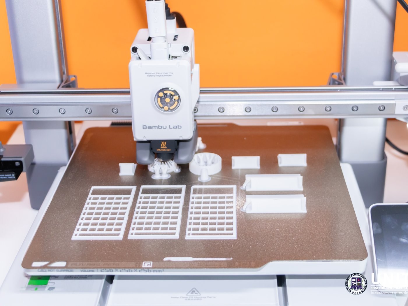 A 3D printer finishing student-designed building components for the model builds