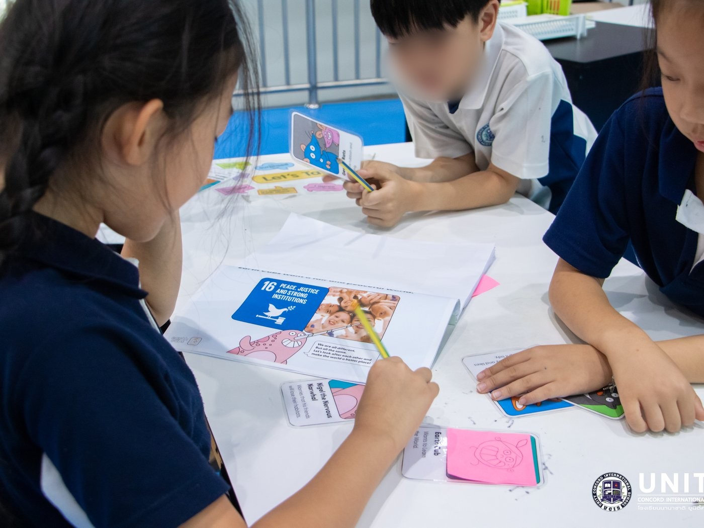 Students playing a habitat card game exploring how pollution and habitat loss affect ocean and land animals