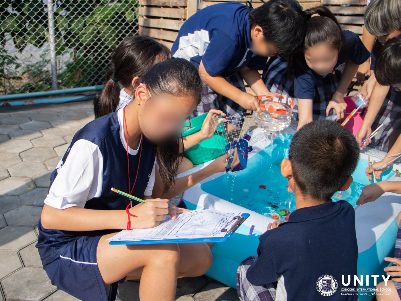 Students cutting mesh netting to build their ocean-cleanup device