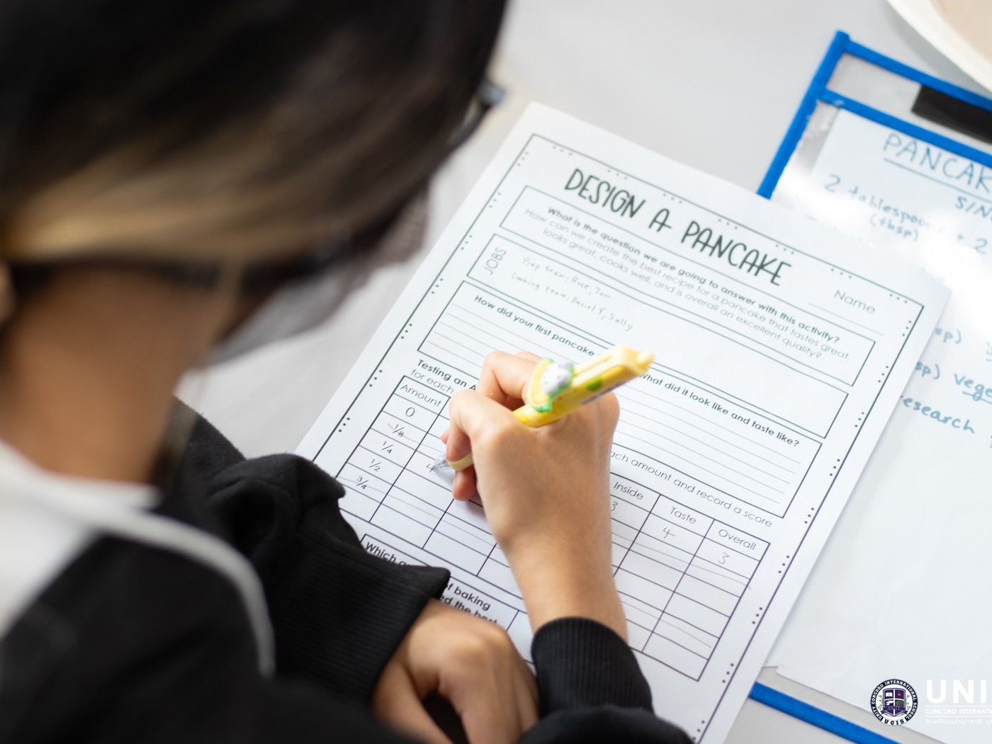 Student recording team jobs on a Design a Pancake worksheet