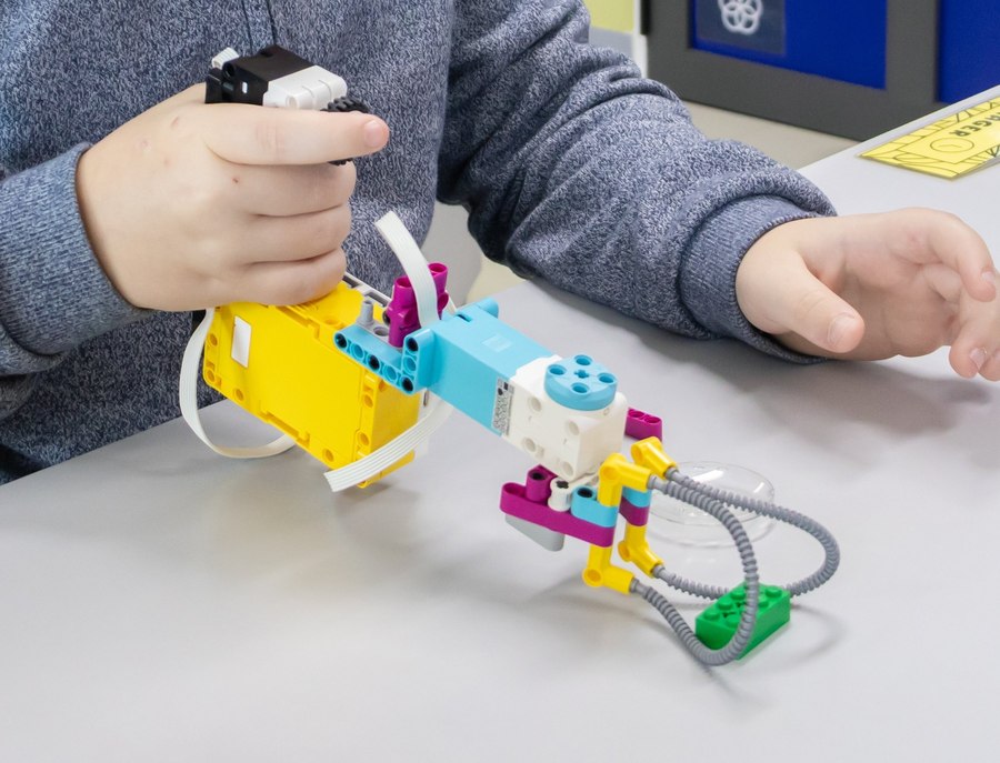 Close-up of a student-built LEGO SPIKE robotic arm with a claw gripper